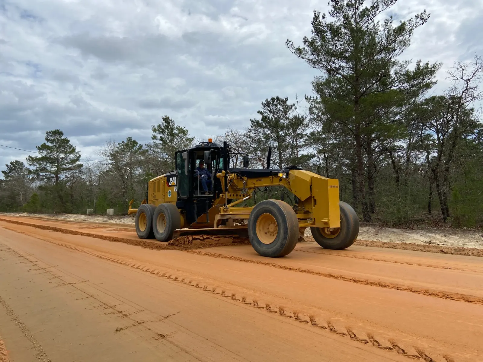 Motor grader shaping a dirt road